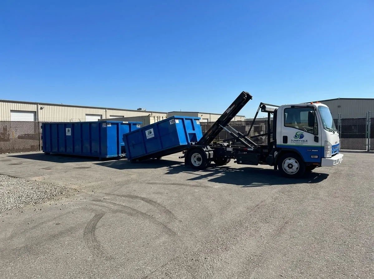 Worker beside a commercial roll-off dumpster from Sunnyvale Dumpster Rental Solutions in Sunnyvale, CA